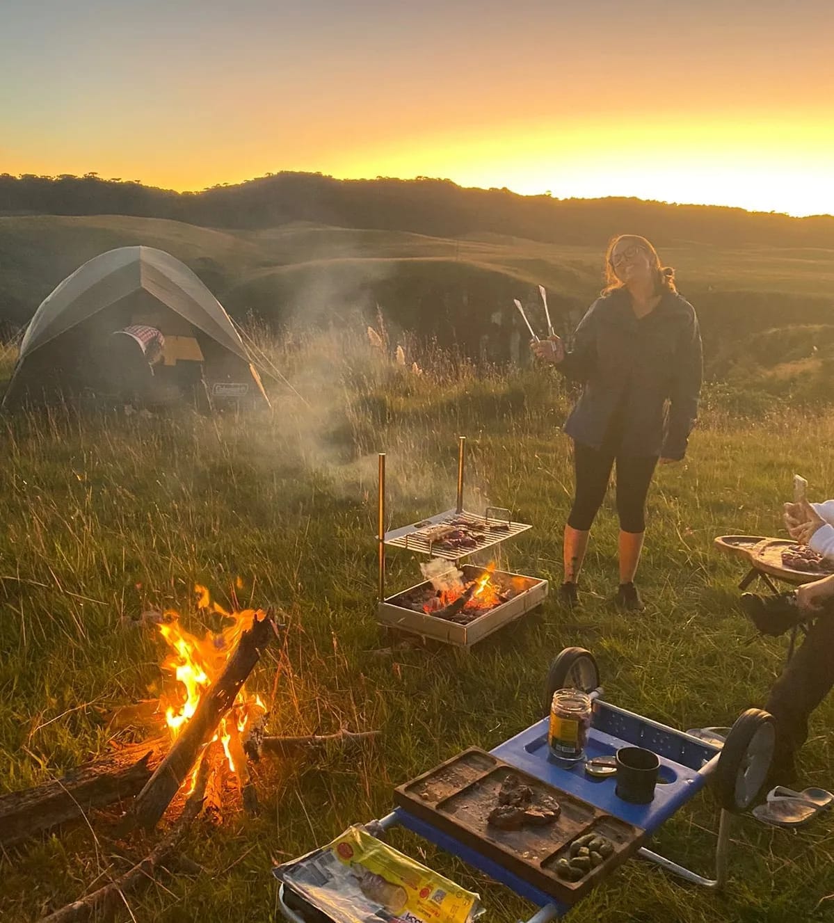 Churrasqueira para camping Ecker Spirit acesa em acampamento à noite